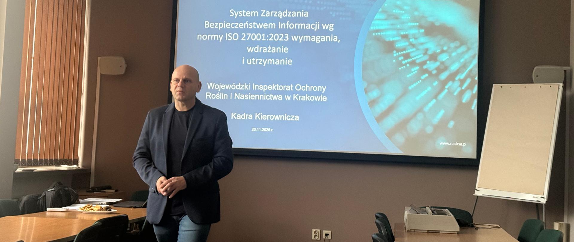 Mężczyzna na sali konferencyjnej, na tle prezentacji