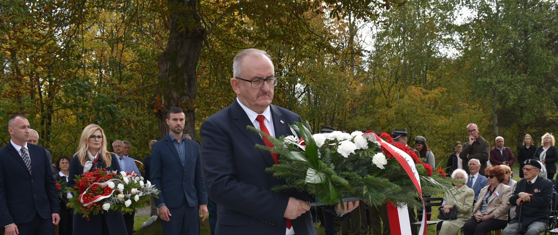 Dyrektor Biura Wojewody składa wieniec. W tle grupa osób.