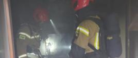 Dwóch strażaków przeszukuje pomieszczenie kuchenne