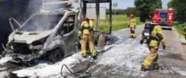 Strażacy gaszą pianą palący się samochód dostawczy