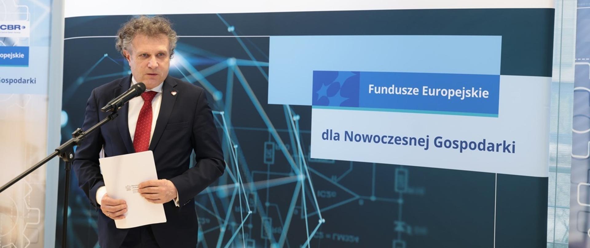 Na zdjęciu wiceminister Jacek Karnowski stoi przed mikrofonem