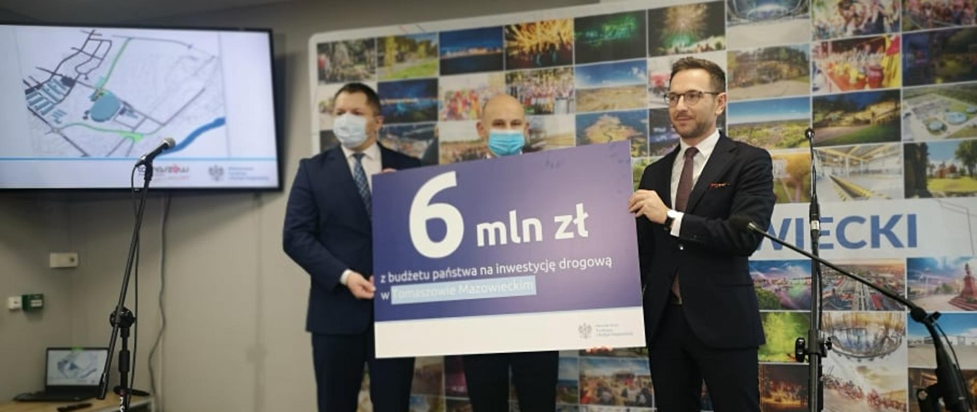 Na scenie trzy osoby, pierwszy z prawej minister Waldemar Buda, w tle kolaż ze zdjęć, po lewej mapa inwestycji.