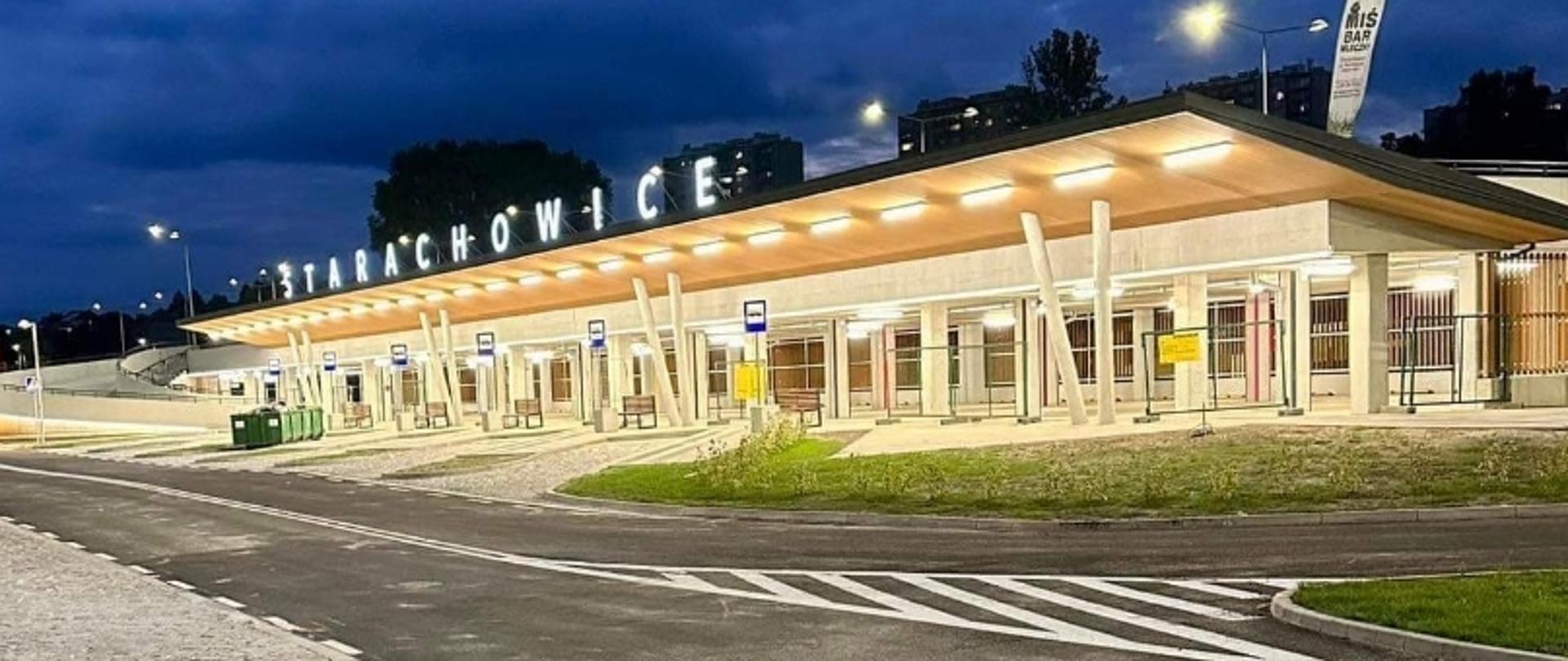 Dworzec autobusowy „Starachowice” nocą z oświetloną wiatą i oznaczeniami przystanków.