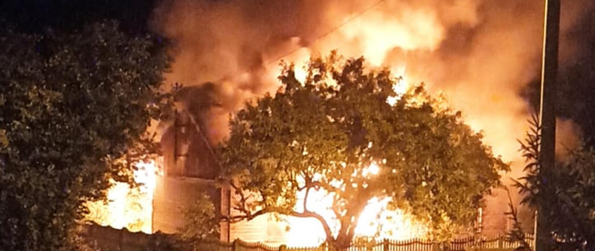 Nocny pożar niezamieszkałego domu, silnie rozwinięty pożar budynku, cały obiekt objęty płomieniami