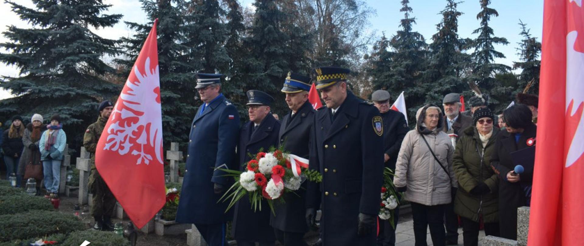 Delegacja służb mundurowych - policja, straż pożarna, służba więzienna oraz straż miejska podczas składania okolicznościowego wieńca na Kwaterze Powstańczej na cmentarzu średzkim podczas obchodów 104 rocznicy wybuchu Powstania Wielkopolskiego