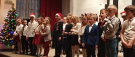 Dzieci z klasy I c6 śpiewają na scenie auli PSM