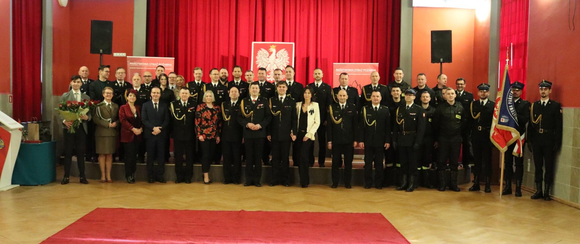 Zdjęcie przedstawia funkcjonariuszy straży pożarnej na uroczystej zbiórce w związku z przejściem na zaopatrzenie emerytalne.