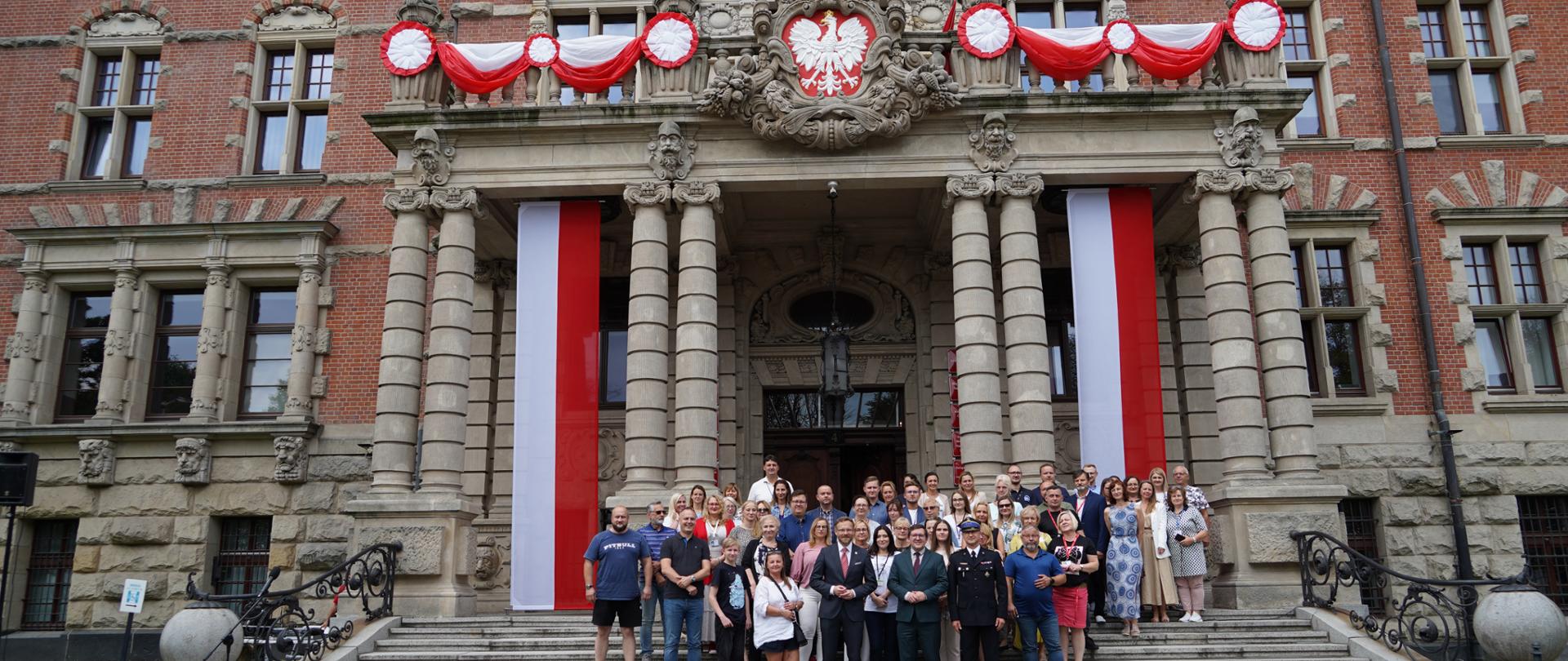wspólne zdjęcie pod przed schodami do wejścia głównego do budynku ZUW