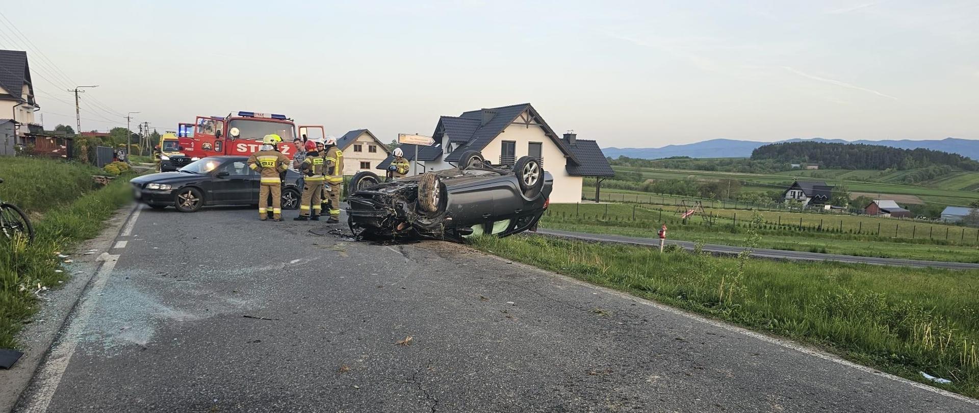 Samochody po zderzeniu na drodze. Jedne na dachu a drugi na kołach.