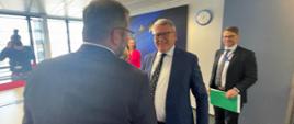 Minister funduszy i polityki regionalnej Grzegorz Puda i komisarz do spraw miejsc pracy i praw socjalnych Nicolas Schmit witają się i uśmiechają się do siebie