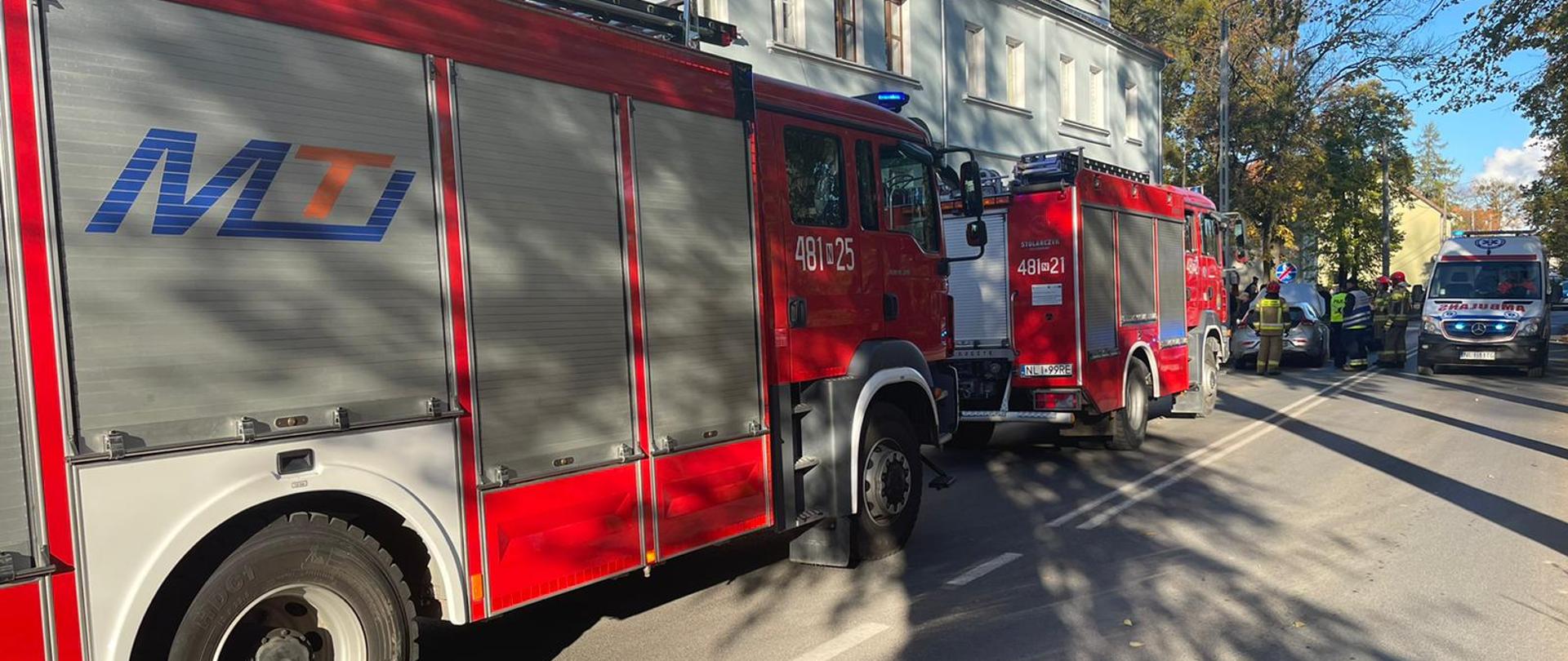 kolizja dwóch aut osobowych przy ulicy Lipowej w Lidzbarku Warm. Zdjęcie przedstawia dwa pojazdy pożarnicze ustawione równolegle do chodnika oraz karetkę pogotowia.