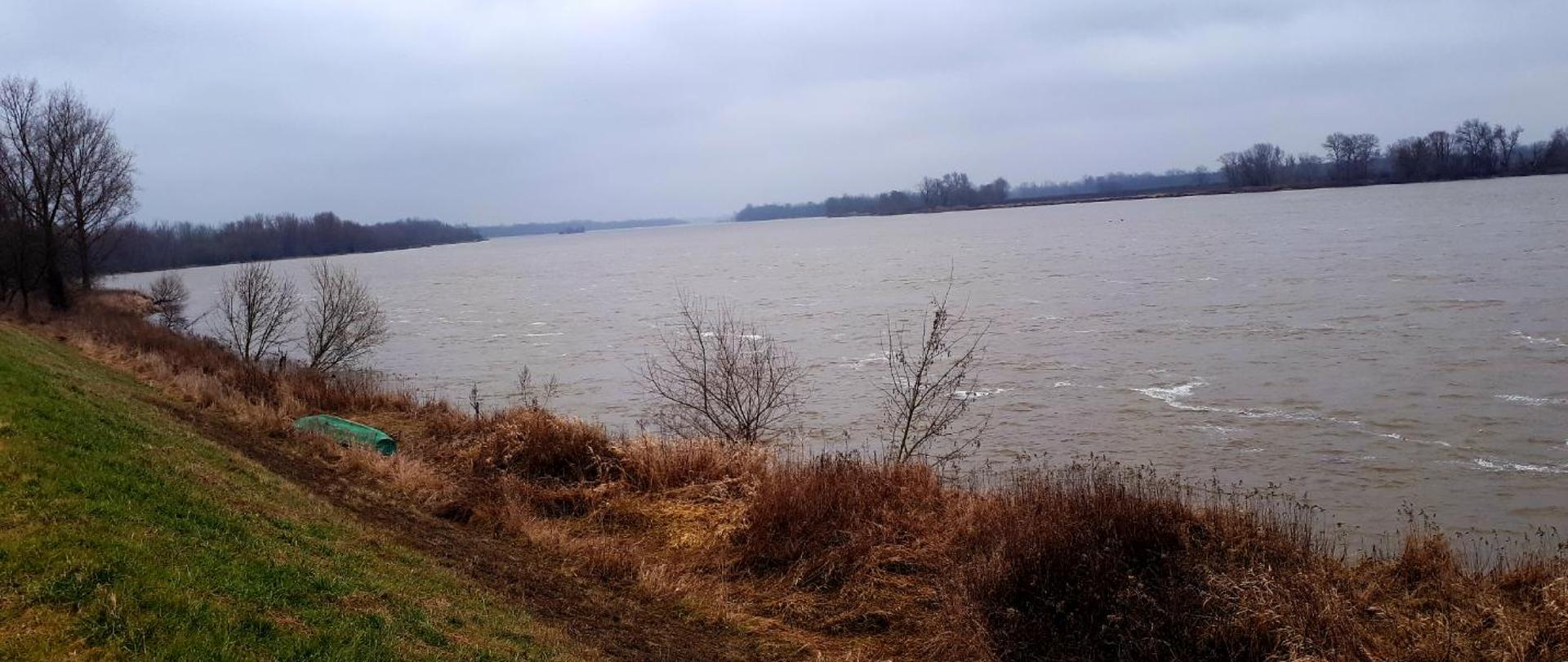 Na zdjęciu rzeka Wisła w powiecie otwockim. Rzeka płynie swobodnie całą szerokością koryta bez utrudnień.