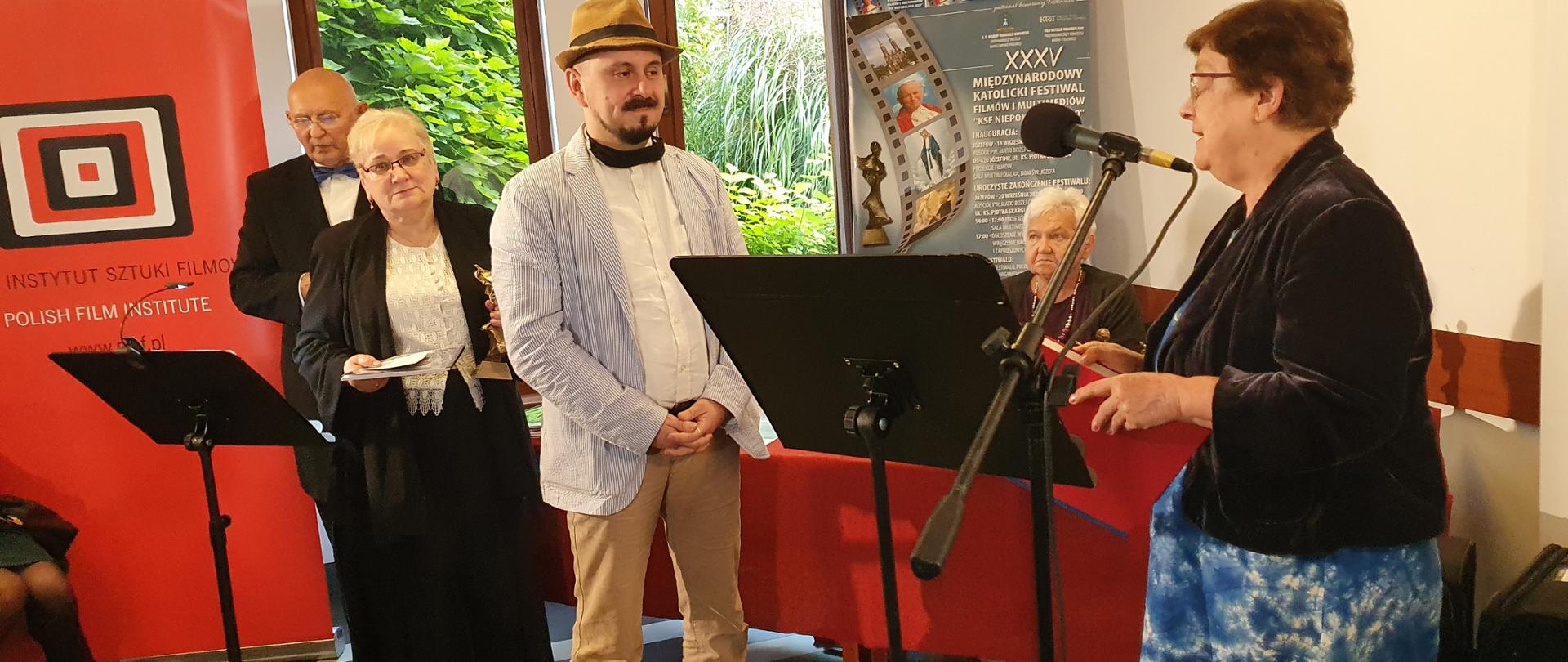 Min. Teresa Bochwic wręcza dyplom laureatowi Nagrody KRRiT. W tle stoją organizatorzy konkursu.