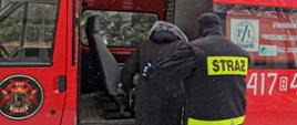 Strażak OSP Dubno pomagający wejść starszej osobie do samochodu pożarniczego w ramach pomocy w dotarciu do punktów szczepień osobom, które nie mogą tam dojechać we własnym zakresie. Działania prowadzone w ramach ogólnopolskiej akcji szczepień przeciw COVID-19