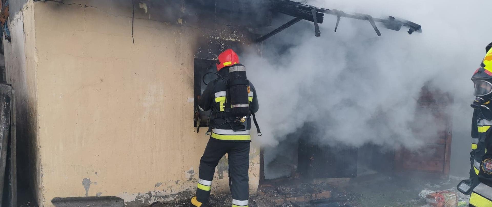 Ratownik gaszący budynek