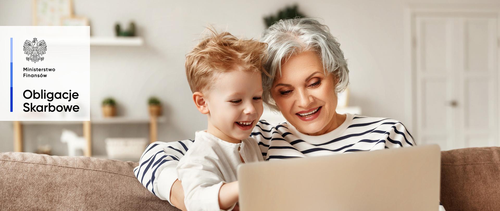 Starsza pani i dziecko przy komputerze.