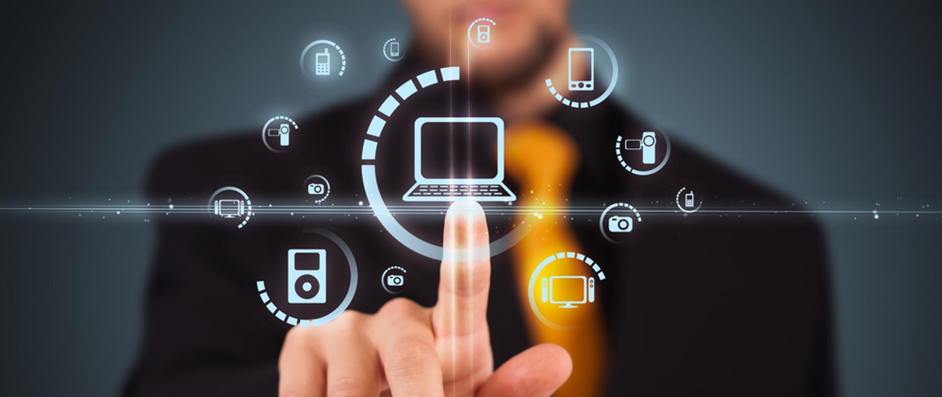 Zdjęcie poglądowe - mężczyzna w garniturze klika w symbol komputera