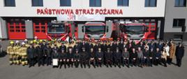 Na zdjęciu goście i strażacy na tle Komendy Powiatowej Straży Pożarnej w Wodzisławiu Śląskim uczestniczący w zbiórce z okazji przekazania samochodów strażackich