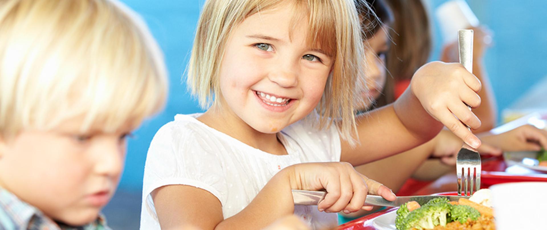 Zdjęcie przedstawia dzieci jedzące posiłek