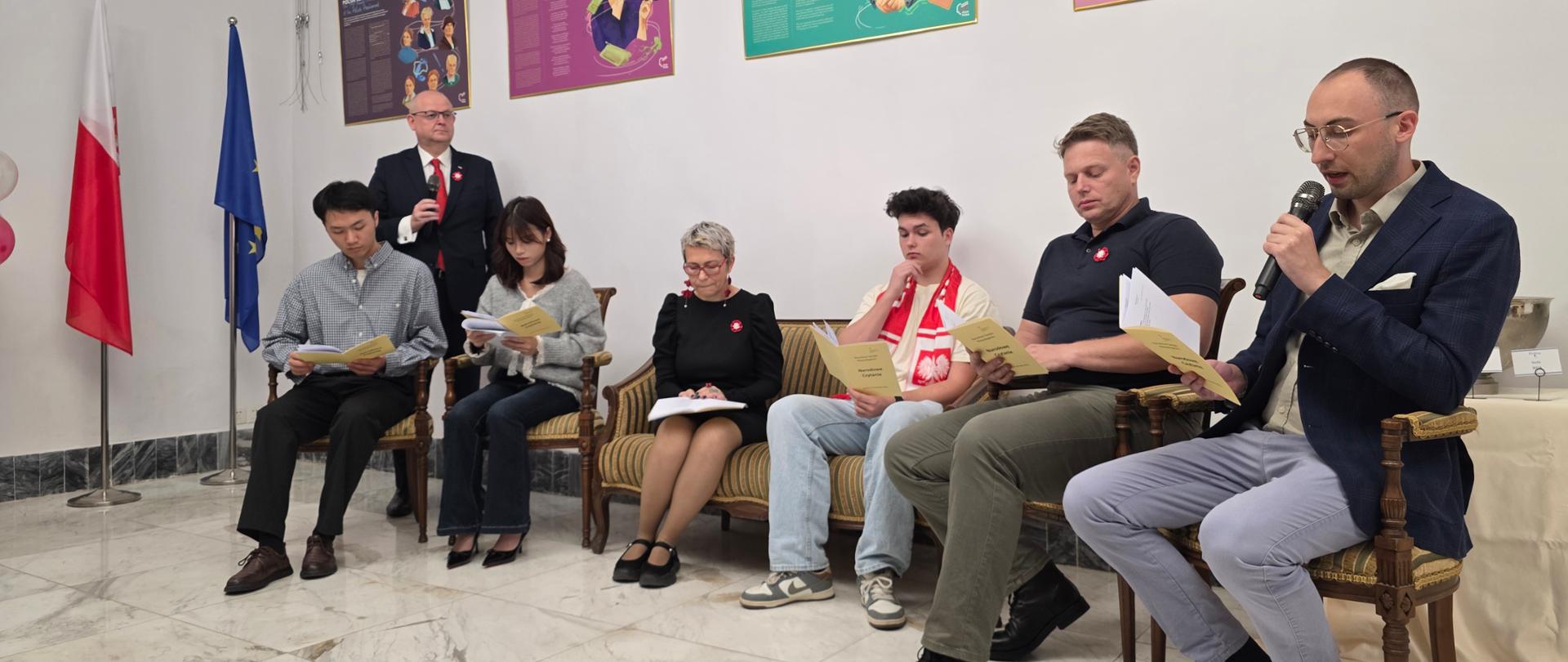 Uczestnicy Narodowego Czytania w sali Konsulatu Generalnego RP w Kantonie, siedzący w półokręgu i czytający utwory Jana Kochanowskiego.