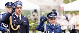 Zdjęcie przedstawia zastępcę komendanta wojewódzkiego PSP oraz zastępcę komendanta wojewódzkiego Policji podczas oddawania honoru po złożeniu kwiatów. 