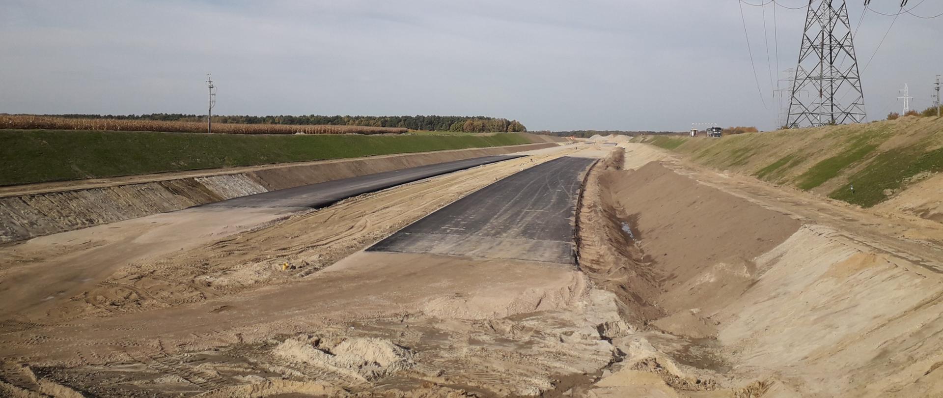 Widok na budowaną drogę. Widoczny duży sup energetyczny. 