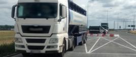 Na pierwszym planie zestaw ciężarowy zatrzymany do kontroli przez patrol mazowieckiej ITD koło Wyszkowa. W tle stoi oznakowany furgon ITD. 