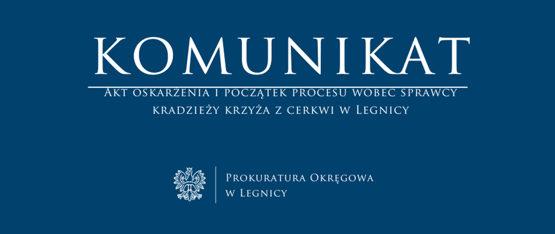 baner - na niebieskim tle napis w kolorze białym Komunikat, poniżej pozioma biała kreska, pod kreską napis "Akt oskarżenia i początek procesu wobec sprawcy kradzieży krzyża z cerkwi w Legnicy", niżej pośrodku rysunek orła oddzielony od napisu Prokuratura Okręgowa w Legnicy krótką pionową kreską