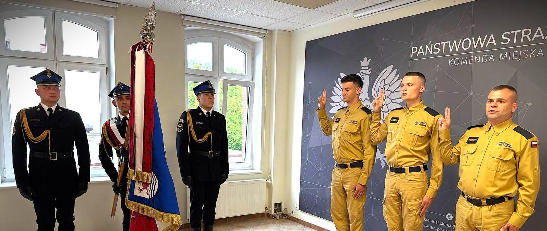 Zdjęcie przedstawia trzech funkcjonariuszy KM PSP podczas ślubowania.