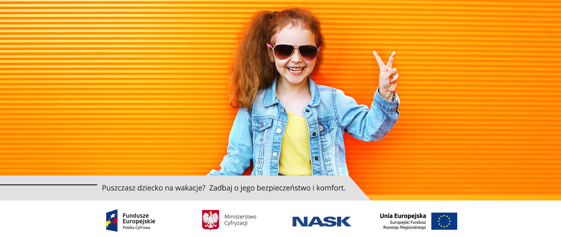 Kilkuletnia uśmiechnięta dziewczynka w okularach słonecznych na tle pomarańczowej ściany. Unosi rękę w geście victorii