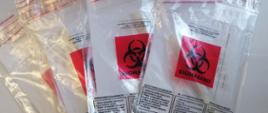 Pakiety testów na owsice w woreczkach strunowych z naklejonym znaczkiem biohazard