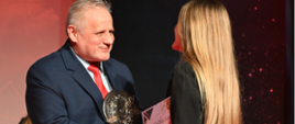 Wicewojewoda Zbigniew Szczypiński wręcza nagrodę i statuetkę - jednej z laureatek gali sportu 