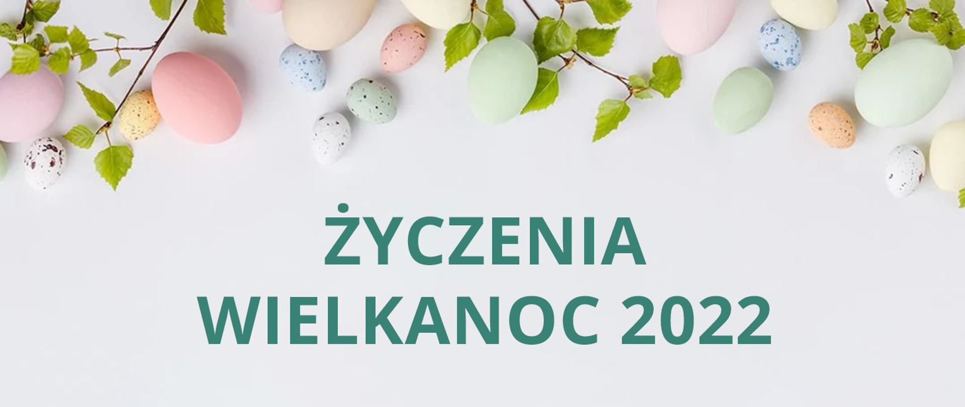 Zdjęcie przedstawia baner o jasnym tle, na górze widoczne są kolorowe duże i małe jajka oraz młode gałązki brzozy. Poniżej napis: Życzenia Wielkanoc 2022.