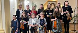 Galeria 12 zdjęć z koncertu uczniów klasy skrzypiec P. K. Ślęzak i wiolonczeli P. P. Machały, który odbył się 08 grudnia 2023. Uczniowie grają na instrumentach na scenie auli PSM w Kłodzku