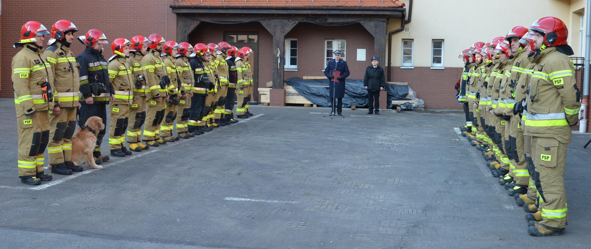 Strażacy w mundurach bojowych w kolorze piaskowym stoją na Placu JRG nr 1 w Wałbrzychu