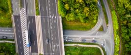 Trójpasmowa autostrada z dwoma pasami włączenia (lewa strona fotografii) i wyłączenia (po prawej stronie) w pobliżu węzła drogowego na przecięciu z lokalnym układem drogowym.