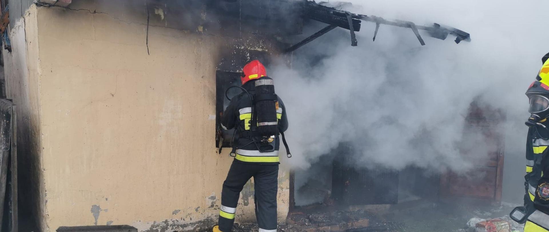 Strażacy gaszący budynek, duże zadymienie