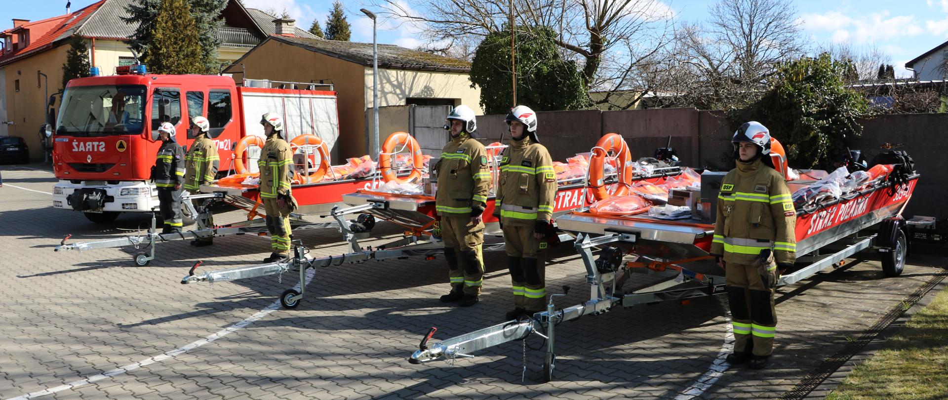 Widoczne trzy łodzie na przyczepach oraz GBA Rt 2/30/2,5 oraz druhowie OSP w ubraniach specjalnych i hełmach