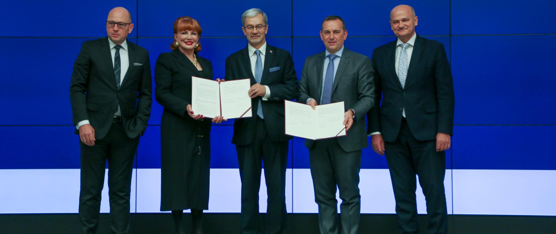 uczestnicy uroczystości prezentują podpisany list intencyjny: wiceprezes ARP Dariusz Śliwowski, ambasador Georgette Mosbacher, minister Jerzy Kwieciński, wiceprezes GE Renewable Energy Fabrice Kermorgant, prezes GE Power Sławomir Żygowski