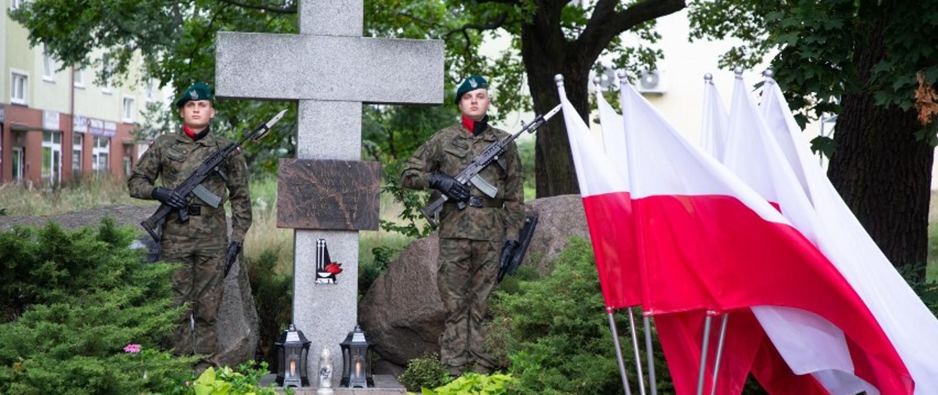 Dwóch żołnierzy pełni wartę honorową przy pomniku Ofiar Sybiru i Katynia