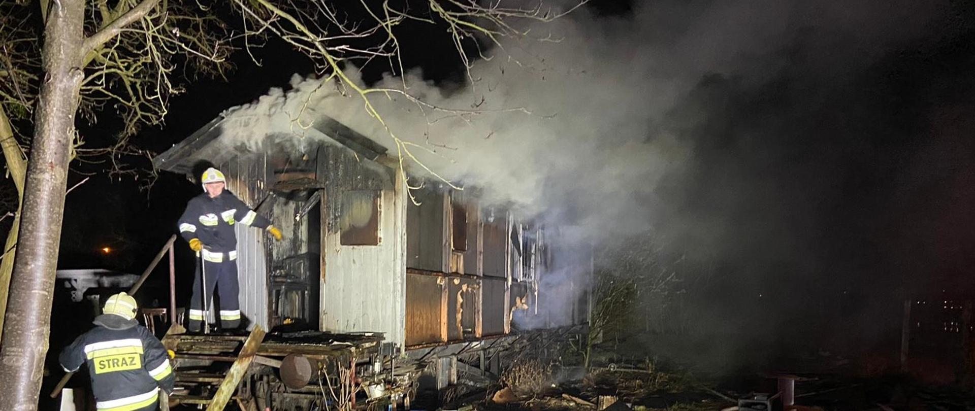 Na zdjęciu widać strażaków przy płonącym wagonie mieszkalnym 