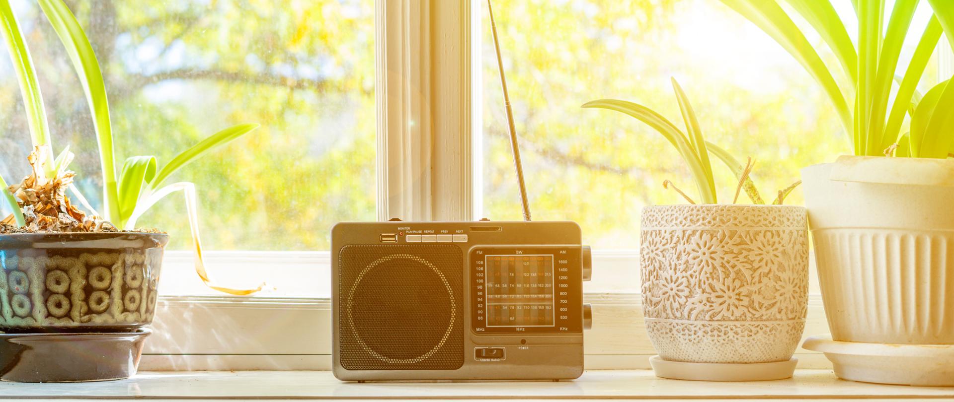 old retro radio with antenna on the window at home playing music