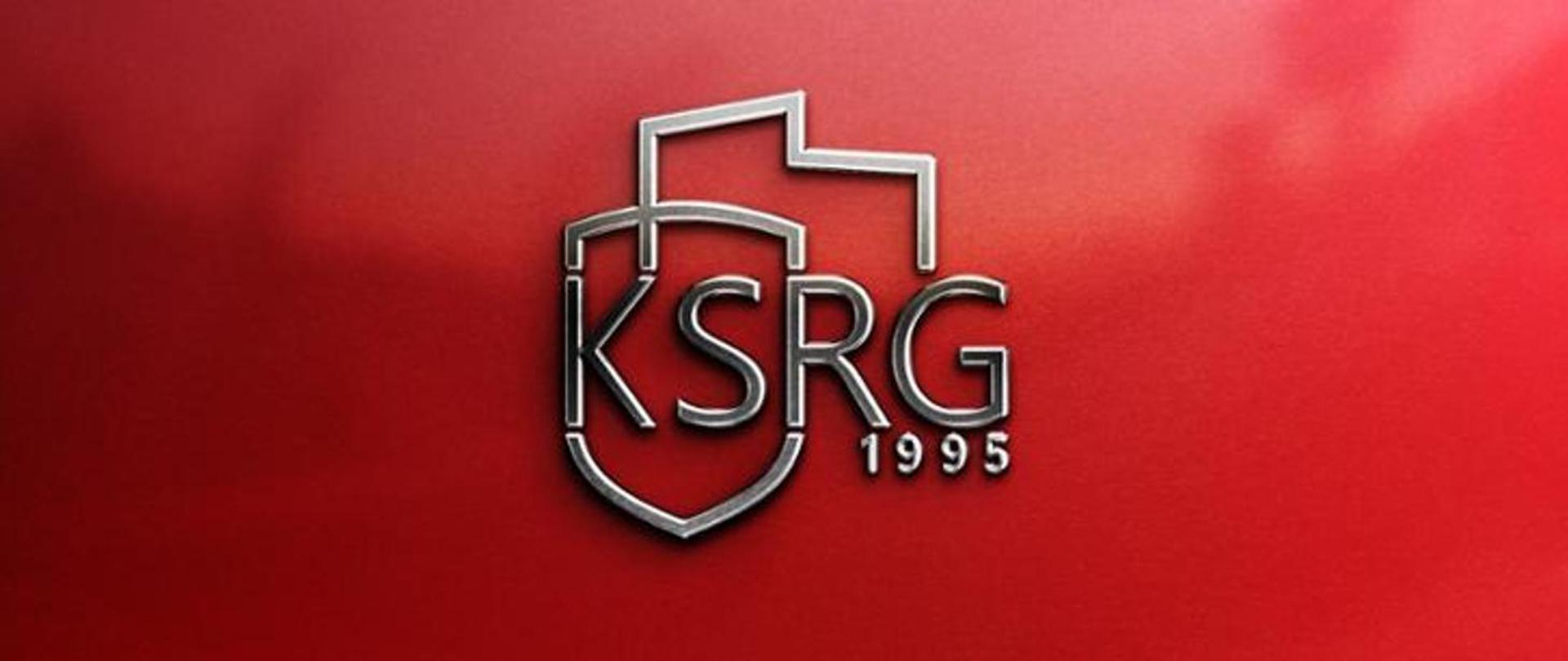 Na zdjęciu widać logotyp ksrg na purpurowym tle 