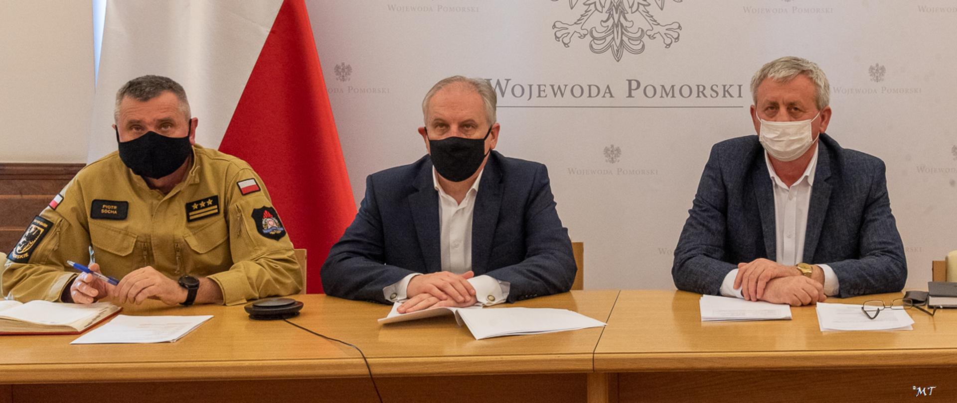 Pomorski komendant wojewódzki Państwowej Straży Pożarnej, wojewoda pomorski oraz dyrektor zarządzania kryzysowego uczestniczą w spotkaniu zespołu zarządzania kryzysowego.