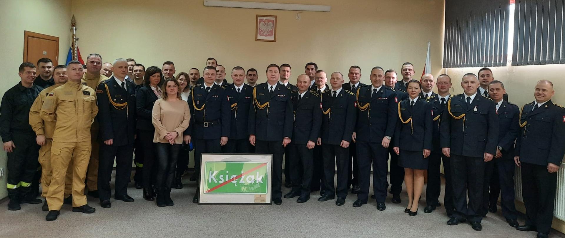 Wspólne zdjęcie funkcjonariuszy, pracowników cywilnych oraz zaproszonych gości z okazji przejścia na zaopatrzenie emerytalne Z-cy Komendanta Powiatowego w Grodzisku Maz. st. bryg. Piotra Księżaka.