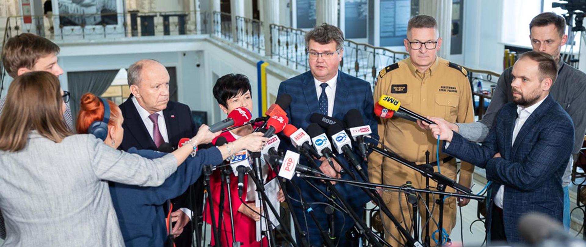 Zdjęcie przedstawia wiceministra Macieja Wąsiaka podczas konferencji na rzecz Młodzieżowych Drużyn Pożarniczych OSP