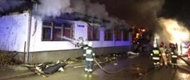 Widok strażaków gaszących stary budynek gminy