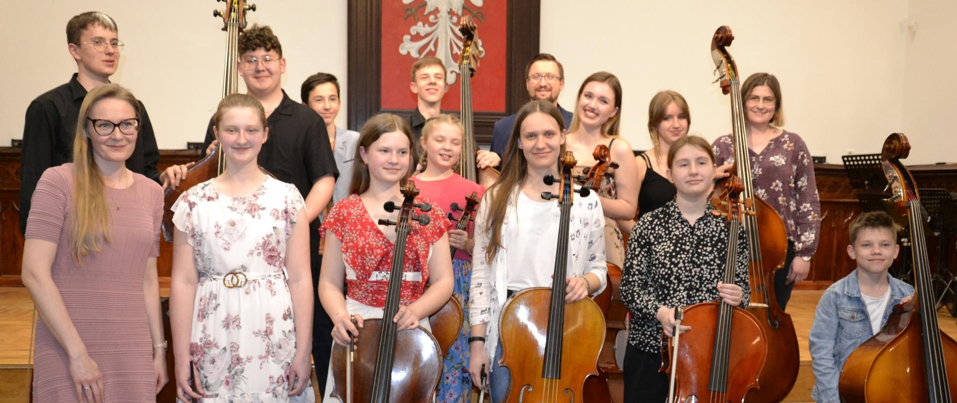 uczniowie klasy wiolonczeli i kontrabasu wraz z nauczycielami podczas koncertu swoich klas na scenie w sali królewskiej PSM w Mielcu