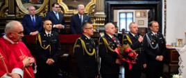 Delegacja strażaków z kwiatami zabiera głos w kościele