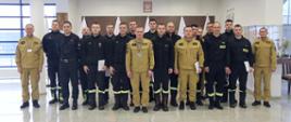 Grupowe zdjęcie uczestników szkolenia (16 funkcjonariuszy PSP) w towarzystwie Zastępcy Komendanta Centralne Szkoły PSP oraz trzech funkcjonariuszy CS PSP